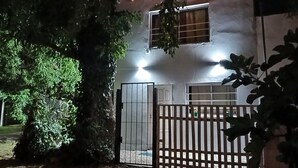 A two-story house with a gated entrance, a visible window, and a tree in the foreground. - House for rent in mar del plata, per day, per week or per fortnight (Mar del Plata)
