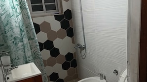 A bathroom with a shower, two toilets, a sink, and a window. - House for rent in mar del plata, per day, per week or per fortnight (Mar del Plata)
