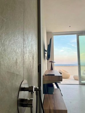 A modern interior with a large sliding glass door leading to a balcony with a view.