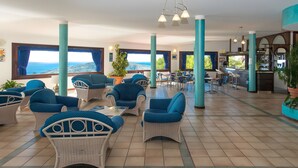 A spacious indoor area with wicker furniture, large windows, and a view of the sea. - P.R. Club - Three-Room Enea 32 with Sea View, Private Terrace and Air Conditioning (Centola)