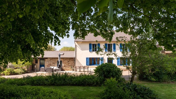 A building with a stone facade, blue shutters, and a well-maintained lawn. - Family Home for 10 Guests (Bannalec)