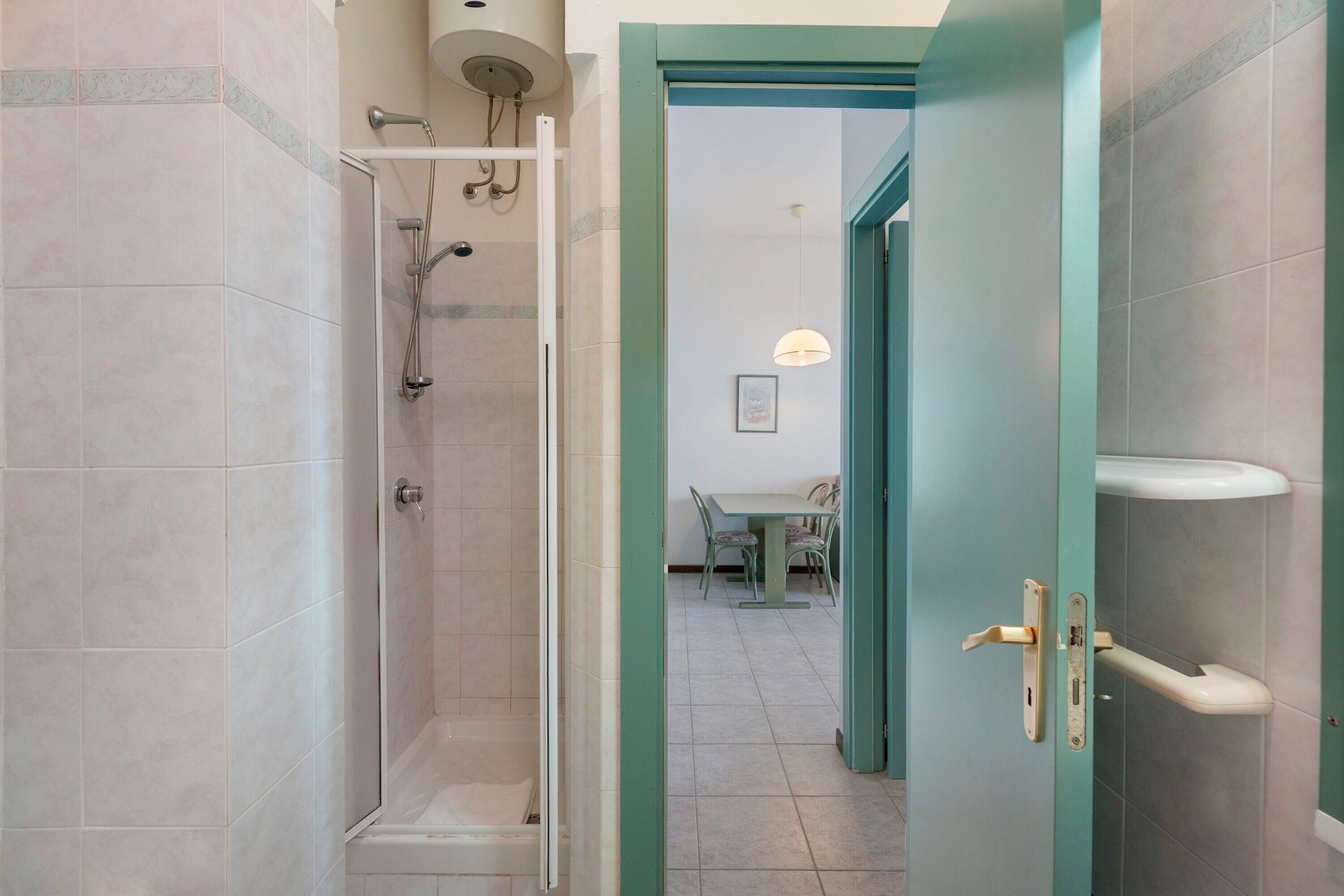Een badkamer met douche, toilet en wastafel.