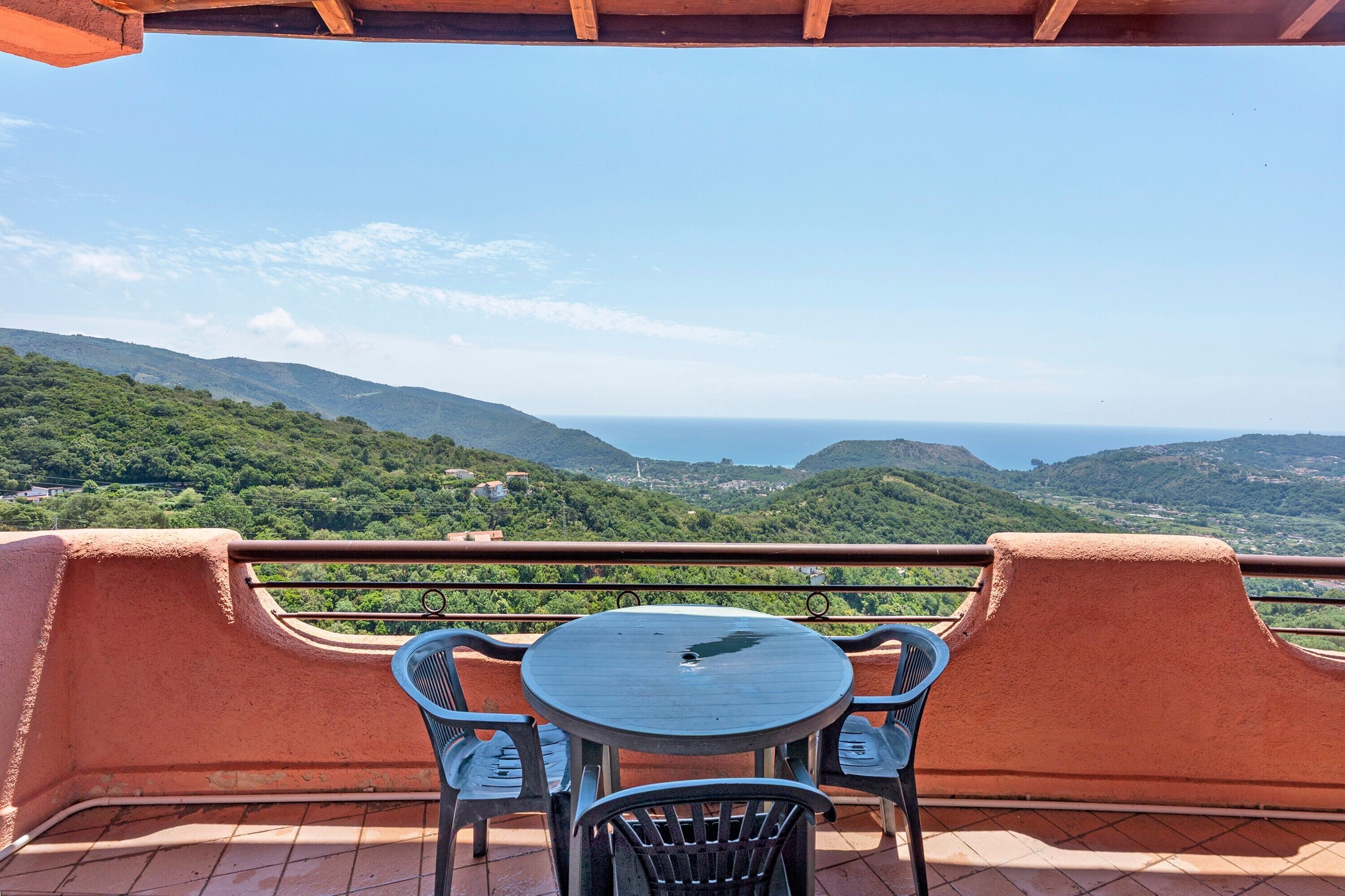 Une terrasse avec une table et des chaises donnant sur un paysage montagneux.