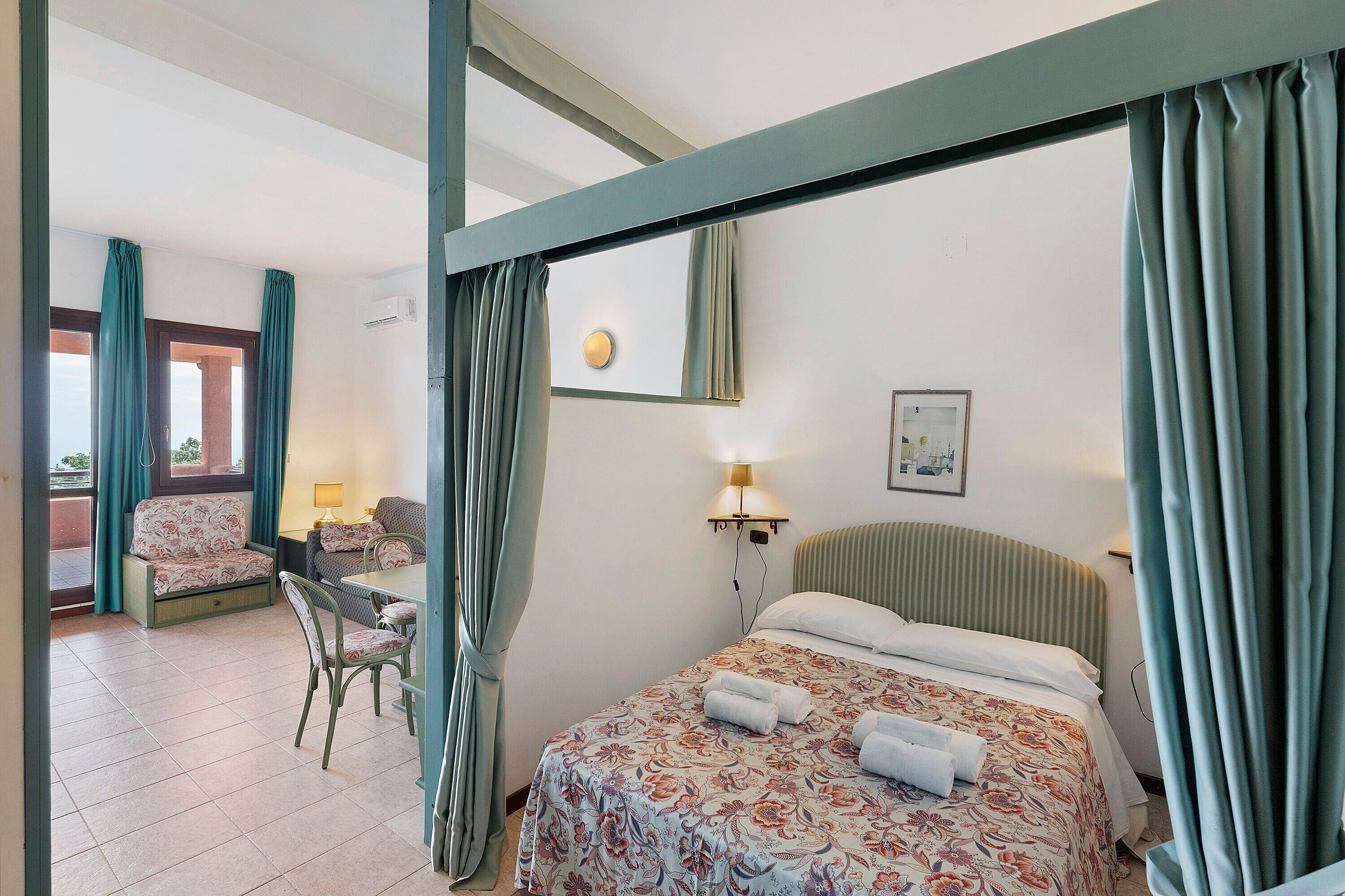 Une chambre d’hôtel avec un lit, une chaise, une table et un bureau.