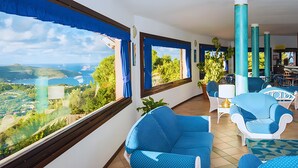 A balcony with blue curtains, wicker chairs, and a view of a coastal landscape. - P.R. Club – Studio Molpa 15' with Sea View, Private Terrace and Air Conditioning (Centola)