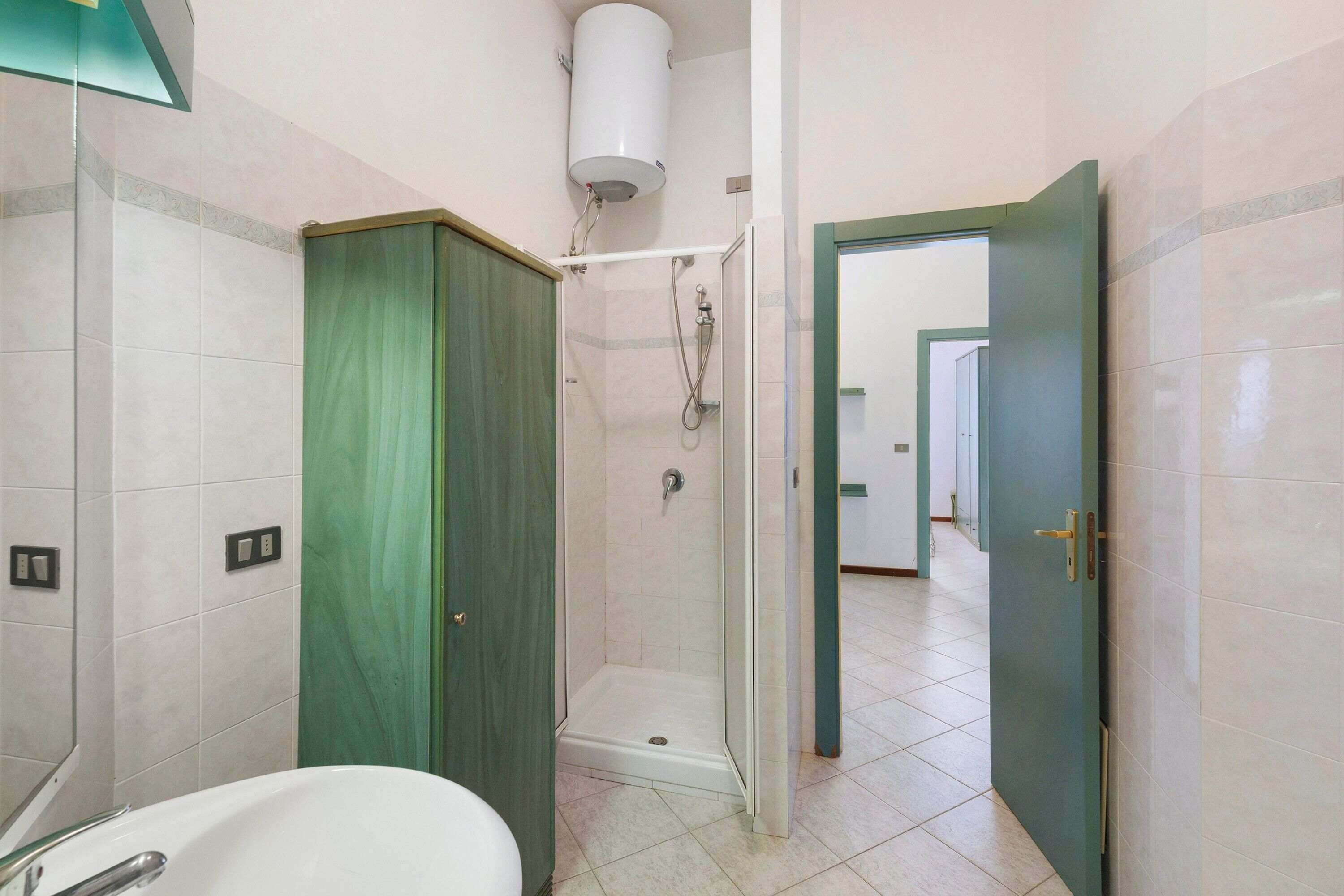 Een badkamer met een douche, toilet en wastafel.