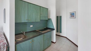 A kitchen with green cabinets, a sink, and a tiled floor. - P.R. Club – Studio Molpa 6 with Sea View, Private Terrace and Air Conditioning (Centola)