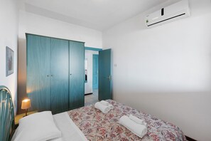 A bedroom with a bed, a nightstand, a lamp, and a wardrobe. - P.R. Club - Studio Molpa 7 with Sea View, Private Terrace and Air Conditioning (Centola)