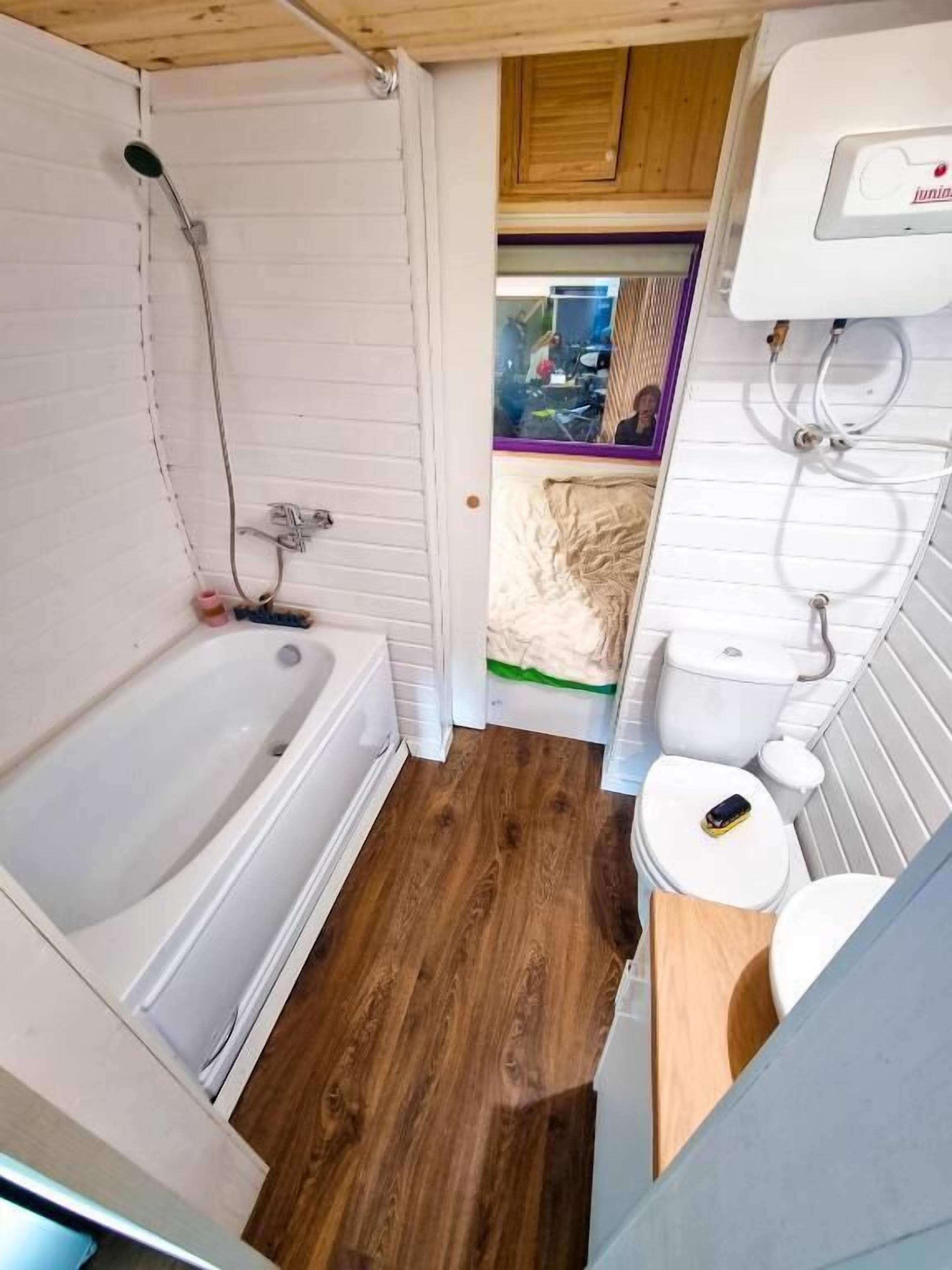 A compact bathroom with a bathtub, toilet, and shower.