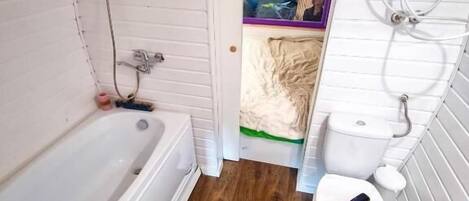A compact bathroom with a bathtub, toilet, and shower.