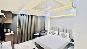A modern hotel room with a large bed, a desk, a chair, and a TV. - Hotel The Season (Ahmedabad)