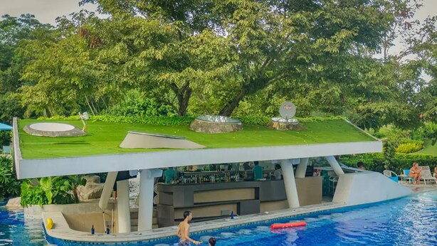 Eine schwimmende Bar mit einer Rasenfläche und einem Poolbereich.