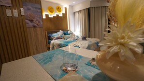 Ein Hotelzimmer mit zwei Betten, einer Wandverkleidung aus Holz, einem fest montierten Telefon und einer dekorativen Blumenanordnung.