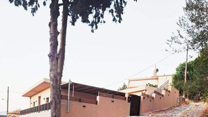 Un sentiero lastricato di pietra conduce a un edificio con tetto piatto e un piccolo balcone.