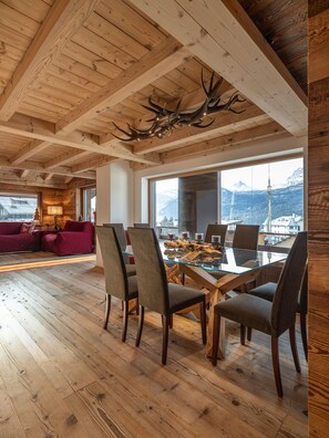 A spacious dining area with a wooden ceiling and large windows offering mountain views. - Casa Poligrafica 2, exclusive and comfortable (Cortina d´Ampezzo)