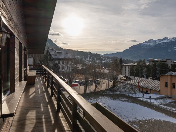 A wooden balcony overlooking a snowy landscape with mountains in the distance. - Casa Poligrafica 2, exclusive and comfortable (Cortina d´Ampezzo)