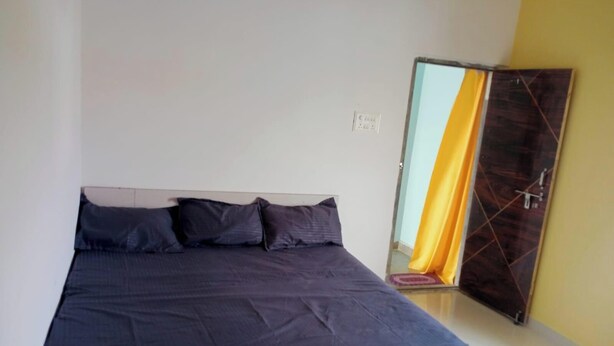 Un dormitorio con cama, espejo y puerta.