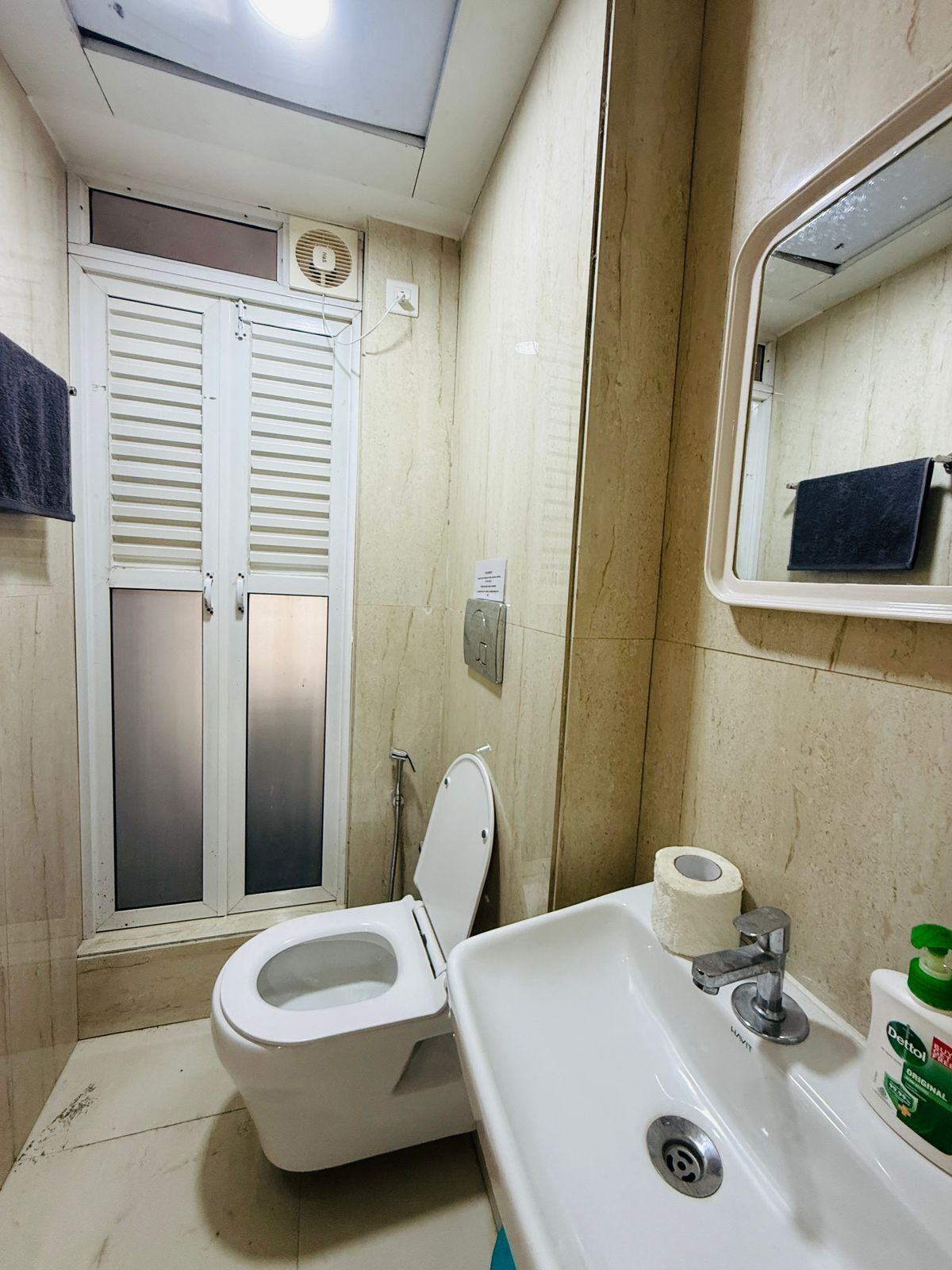 A bathroom with a toilet, sink, and mirror.