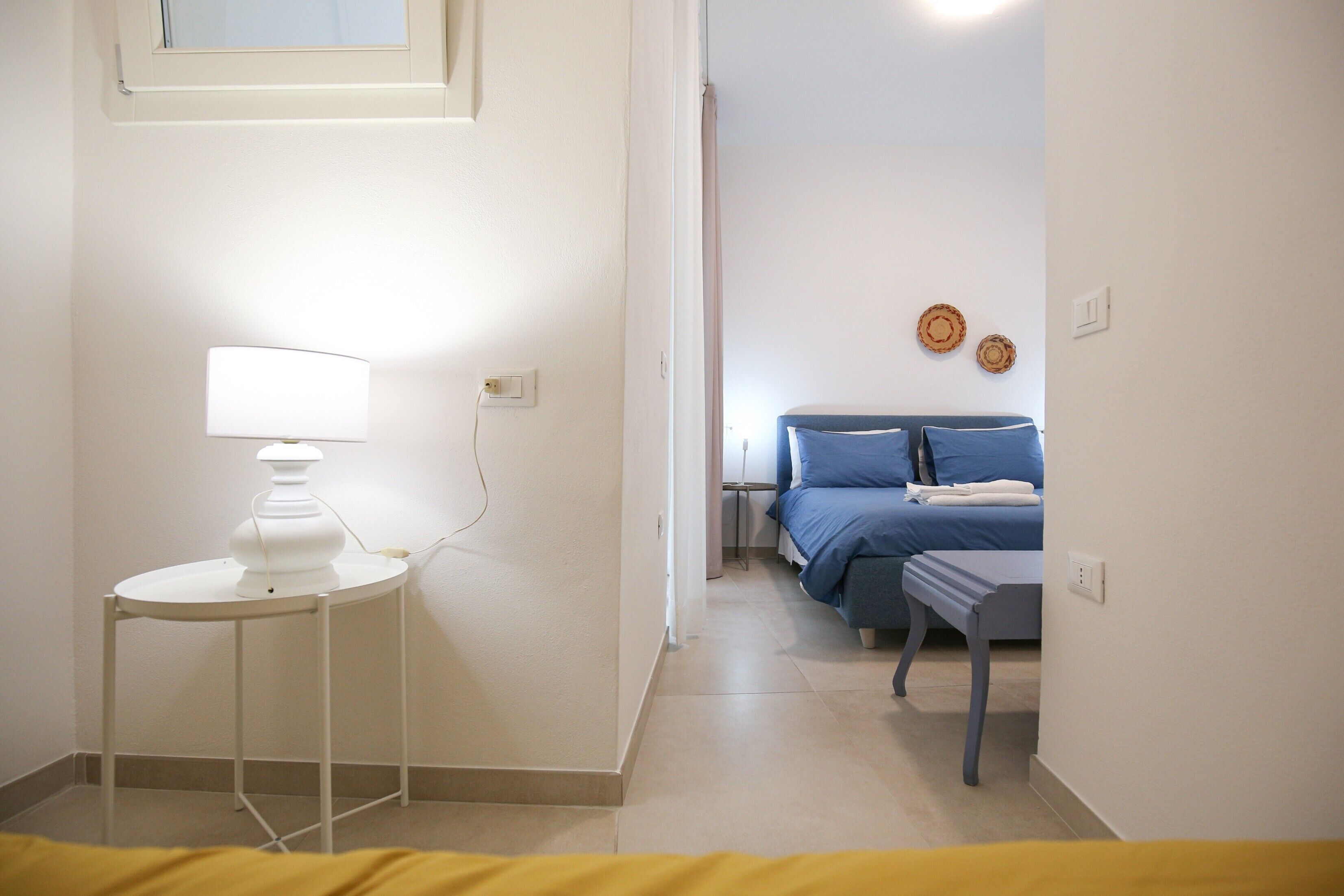 Una habitación de hotel con cama, mesita de noche, lámpara y decoración en la pared.
