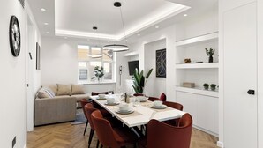 A modern dining area with a long table, red chairs, and white walls. - Apartment - Sleeps 8 - Golders Green 10 Mins (London)