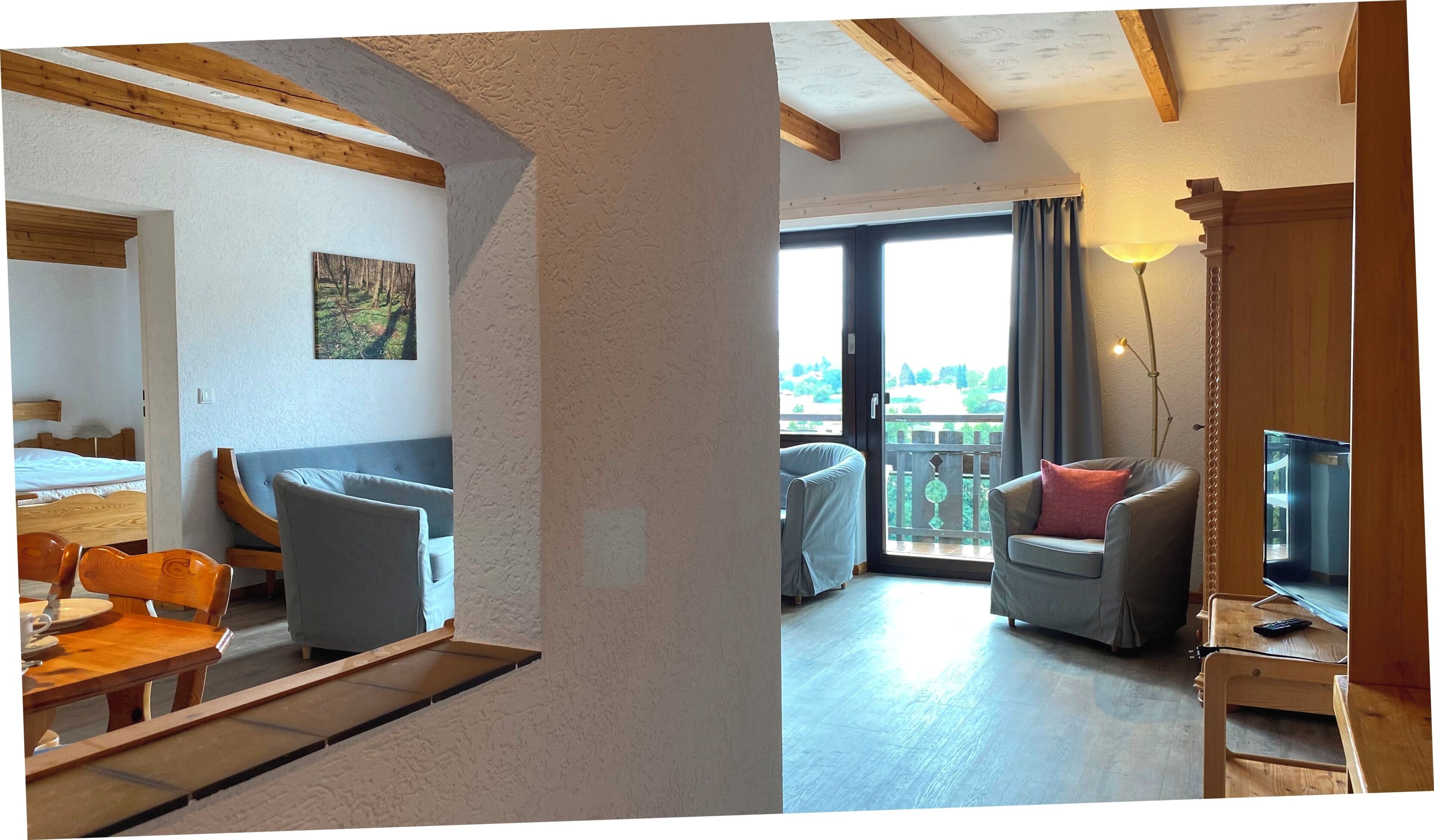 Une pièce comprenant un lit, une table à manger et une chaise. Il y a un tableau au mur et une fenêtre avec des rideaux.