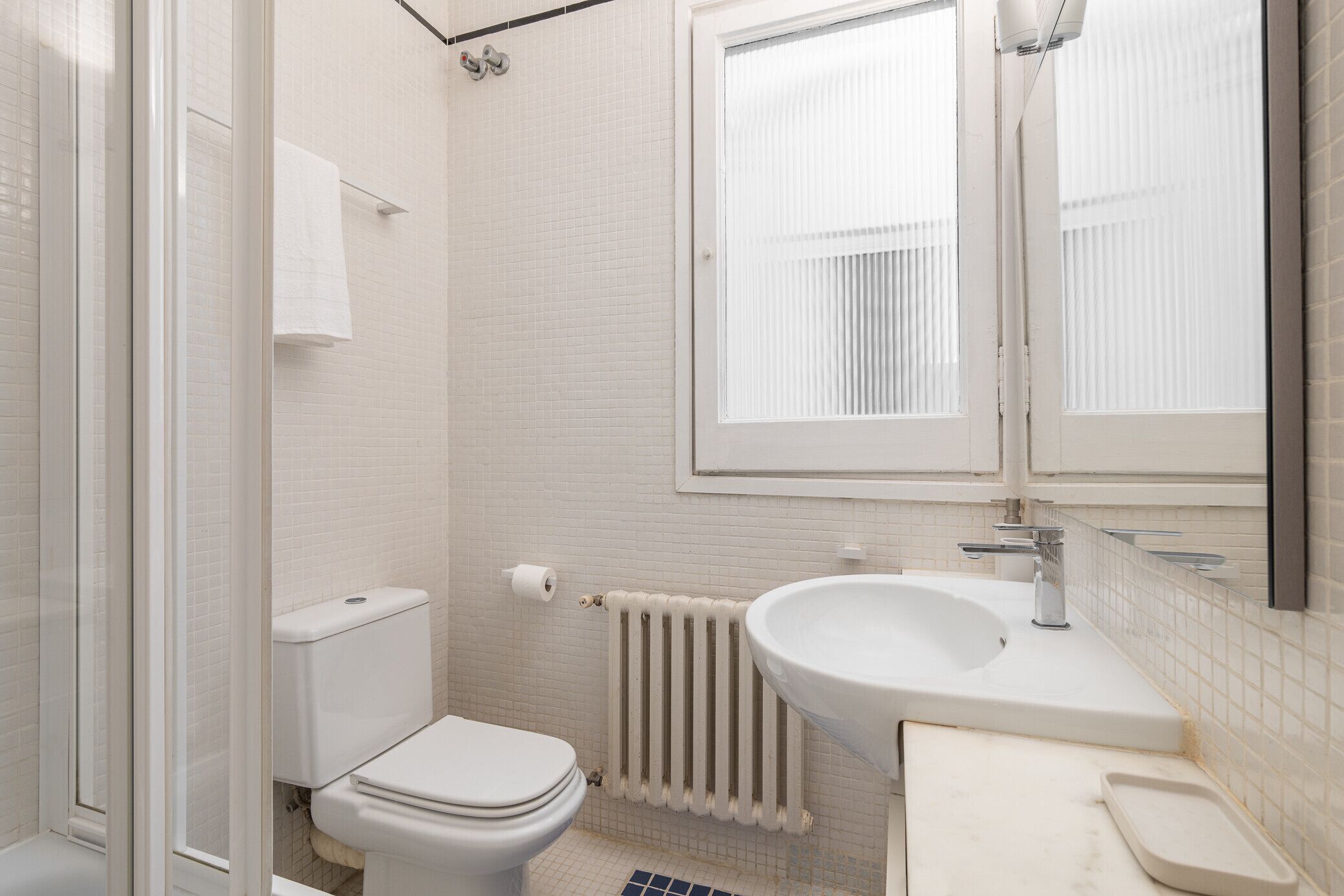 Un baño con inodoro, lavabo y ventana.