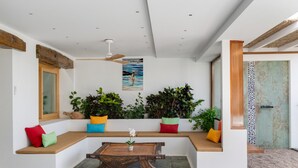 A modern interior with a wooden bench seating area, a central table, and potted plants. - Holiday Apartment 'El Alcaidón 1' with Wi-Fi and Air Conditioning (Tías)