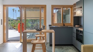 A modern kitchen with a dining area, large windows, and a view of palm trees. - Holiday Apartment 'El Alcaidón2' with Wi-Fi and Air Conditioning (Tías)