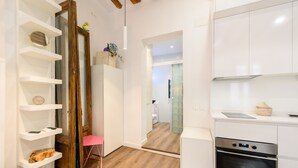 Una cocina moderna con armarios blancos, horno integrado y piso de madera.