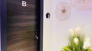 A door with a 'B' sign, a mailbox, and decorative umbrellas on the wall. - Apartment 65B · Oceanfront with Private Terrace (Aguilas)