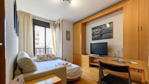 A hotel room with a bed, a desk, a television, and a window with curtains. - M (SAM12) Fantastic one bedroom apartment in Madrid (Madrid)