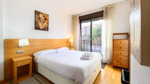 A hotel room with a large bed, bedside lamps, a wooden dresser, and a painting on the wall. - M (SAM12) Fantastic one bedroom apartment in Madrid (Madrid)
