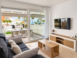 A modern living room with a sofa, coffee table, and TV. - Apartment 65A · Oceanfront with Private Terrace (Aguilas)