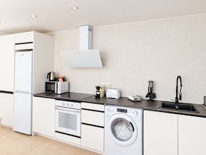 A modern kitchen with a built-in washing machine, oven, and microwave. - Apartment 65A · Oceanfront with Private Terrace (Aguilas)