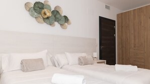 Une chambre d’hôtel avec deux lits, une armoire en bois et un élément décoratif mural.