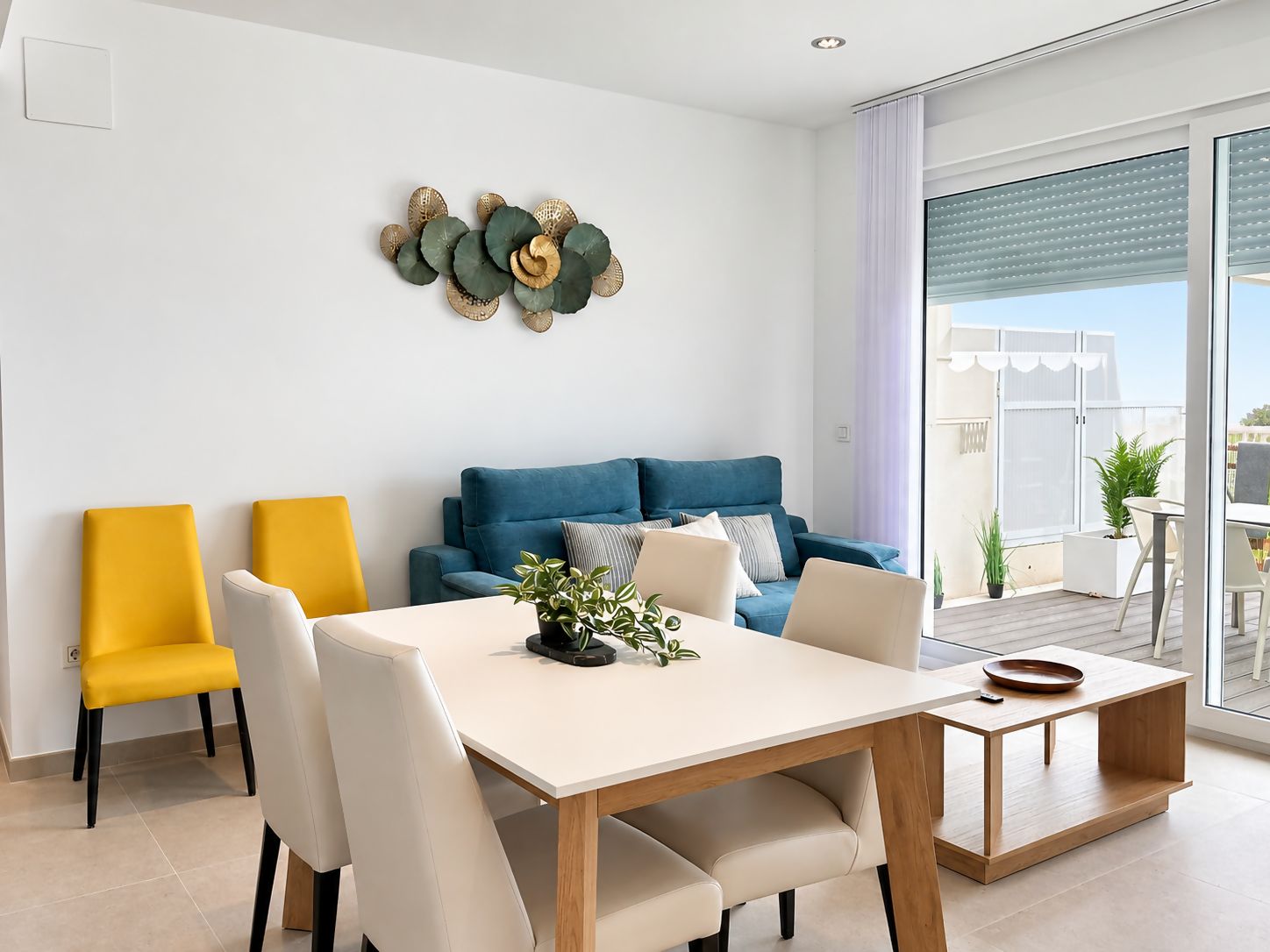 Een moderne woonkamer met een bank, stoelen, een eettafel en een decoratief wandobject.