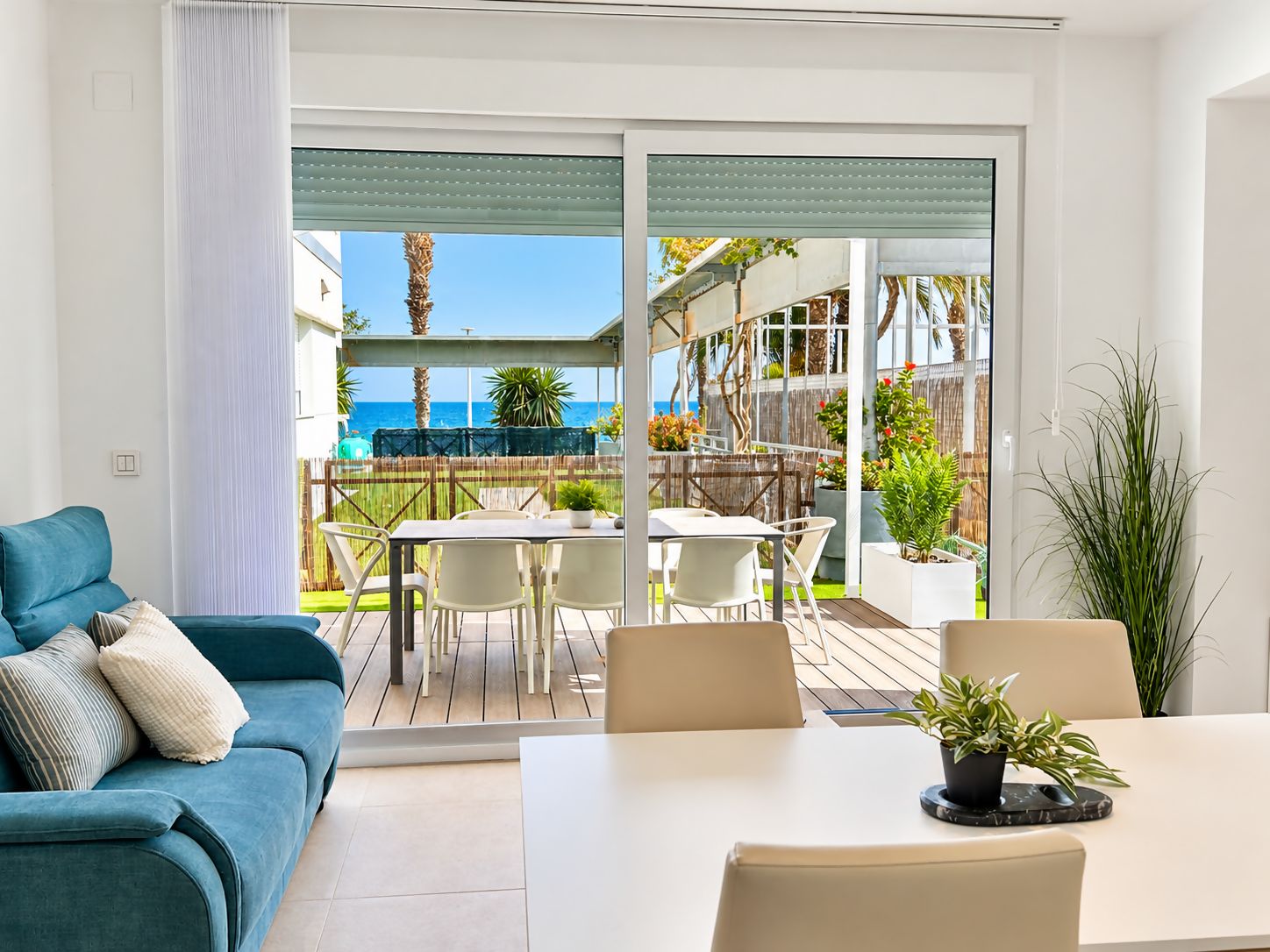 Un salon moderne avec un canapé, une table à manger et une vue sur la terrasse extérieure.