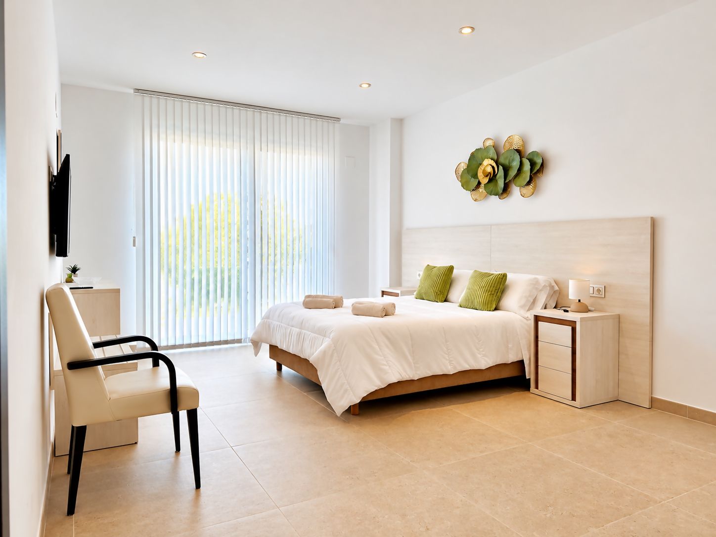 Een moderne hotelkamer met een bed, nachtkastjes, een bureau en een stoel.