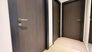 A hallway with two dark wooden doors, a metal handle, and a tiled floor. - Home 65F - Beachfront with Private Terrace (Aguilas)