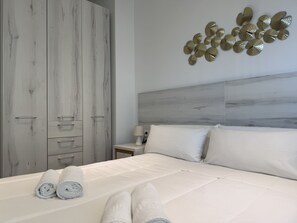A bedroom with a bed, a nightstand, a lamp, and a wardrobe. - Home 65F - Beachfront with Private Terrace (Aguilas)