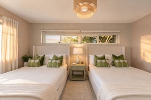 A bedroom with two beds, a window with a view, a bedside table with a lamp, and a decorative ceiling light. - Your Own Private Luxe Resort – 12 Mins to Beach! (West Palm Beach)