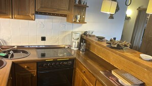 A kitchen with wooden cabinets, a built-in oven, a coffee maker, and a microwave. - Complete Winterberg residence Fichtenweg 54, near the slopes and Bikepark. (Winterberg)
