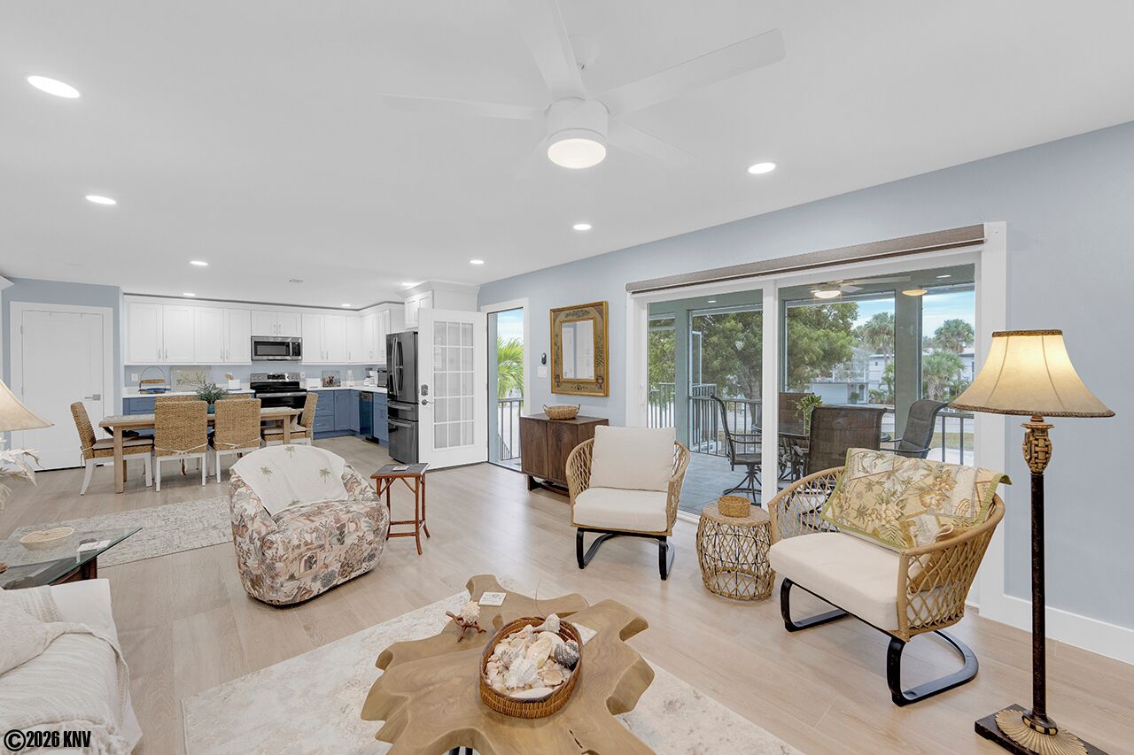 A spacious living area with a dining set, two sofas, a coffee table, and a floor lamp.