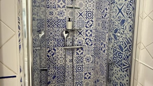 A shower with a geometric tile pattern and a handheld showerhead. - Marina - Magnifique Appartement - Exclusive (Villeneuve-Loubet)