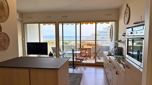 Eine moderne Küche mit einer großen Kochinsel, ein Essbereich mit Blick und ein Balkon mit Meerblick.