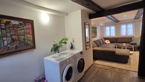 Una sala de estar con sofá, mesa de centro y lavadora.