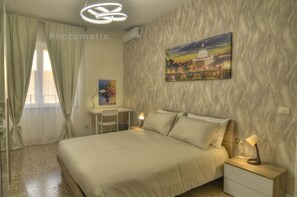 A bedroom with a bed, bedside tables, a desk, and a painting of a cityscape. - Your corner of the Sun in Rome, in a few minutes you are in the center of Rome (Roma)