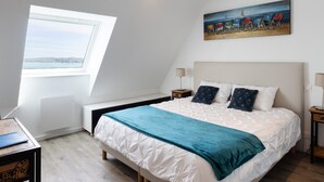 Une chambre à coucher avec un lit, un tableau, une fenêtre et un bureau.