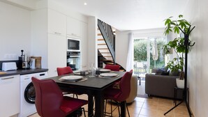 Eine moderne Küche mit Essbereich, einer Treppe und Blick ins Freie.