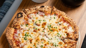 A pizza on a wooden board.